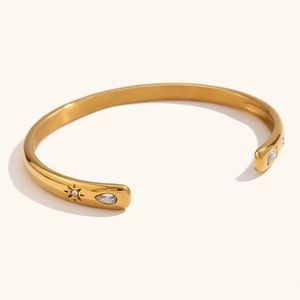 Detailed macro of 18K gold plated cuff bracelet with pear and square cut zircons