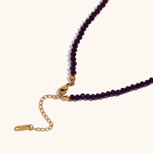 Dettaglio della chiusura a moschettone in oro 18K e perle di cristallo viola sfaccettate