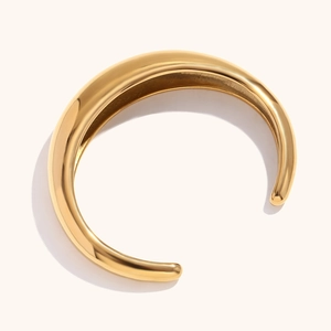 Detalle del brazalete abierto en forma de C de acero inoxidable pulido bañado en oro 18k