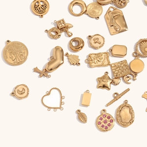 Gros plan de pendentifs en acier plaqué or 14K incluant des formes cœur et pièces