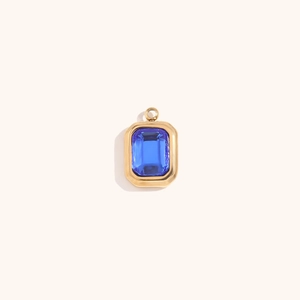 Close-up of 18K gold plated rectangular pendant with emerald-cut blue gemstone