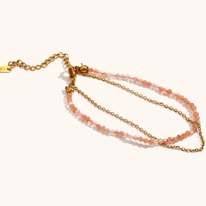 Detail van een 18K vergulde dubbellaagse armband met natuursteen en een karabijnsluiting