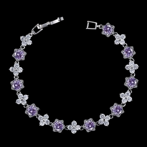 Détail d'un bracelet à maillons argentés avec fleurs en zircon violet et trèfles