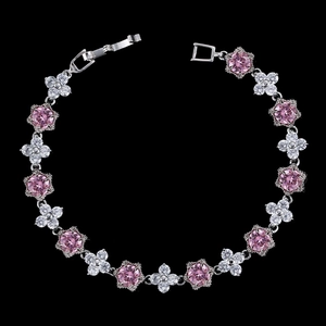 Détail du bracelet en argent avec pierres roses et fleurs blanches sur fond noir élégant