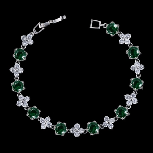 Détail d'un bracelet en zircon vert émeraude avec fleurs blanches et fermoir pliant