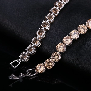 Gros plan du bracelet tennis en zircon champagne avec monture argentée et fermoir pliable
