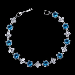 Détails d'un bracelet en argent avec zircons bleus et cristaux en forme de fleurs blanches