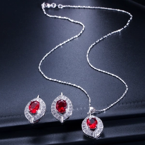 Detailansicht eines silbernen Brautschmuck-Sets mit ovalen roten Rubinen und Kristallen