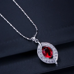 Detailaufnahme einer silbernen Halskette mit Marquise-Anhänger und dunkelrotem Edelstein