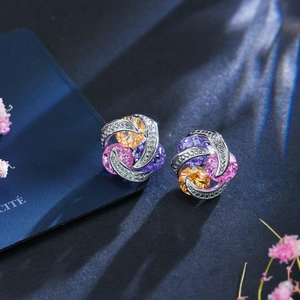 Détail des boucles d'oreilles en zircon avec pierres tricolores violet orange rose