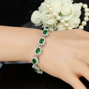 Vue détaillée du bracelet plaqué or blanc 18K avec des pierres précieuses vert émeraude
