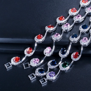 Detailweergave van zilverkleurige armbanden met gekleurde ovale stenen en zirkoonranden