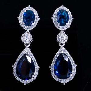 Vue détaillée de longues boucles d'oreilles avec pierres bleues et zircons