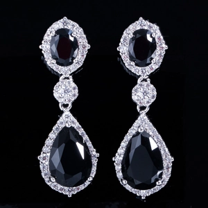 Détail de boucles d'oreilles longues avec pierres noires et pavé de zircone cubique