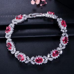 Gros plan détaillé d'un bracelet en argent avec pierres rouges ovales et oxydes de zirconium