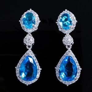 Détail de boucles d'oreilles pendantes en argent avec des pierres bleues facettées