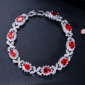 Détail d'un bracelet argenté avec zircons rouges ovales et grappes étincelantes en micro-pave