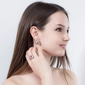 Elegante set di gioielli con pietre rosse a goccia indossato da una modella