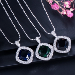 Détail de pendentifs halo carrés bleus, verts et noirs sur des chaînes à boules