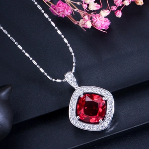 Vue rapprochée du collier pendentif rubis rouge avec entourage de zircons étincelants