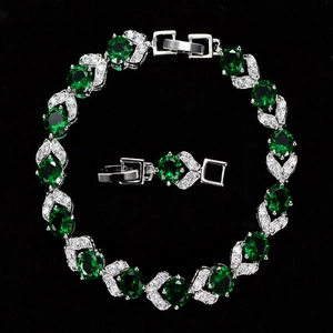 Detalle de pulsera de plata con piedras verdes ovaladas y halo de cristales blancos