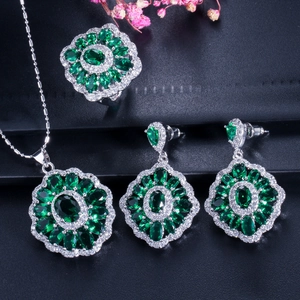 Macro shot of silver-tone vintage jewelry set with emerald green stones and zircon accents