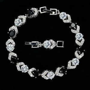 Detalle de pulsera plateada con circonitas AAA, piedras negras y cierre desplegable