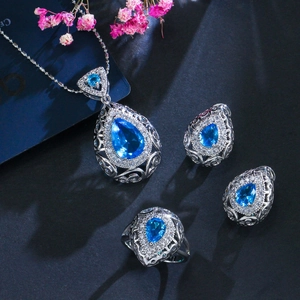 Dettaglio macro del set di gioielli vintage in argento con pietre blu a goccia e zirconi