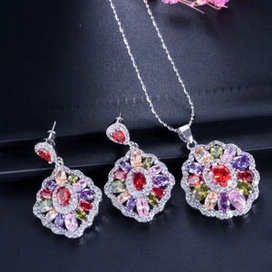 Macro view of three-piece jewelry set with colorful zircon floral pendant and earrings
