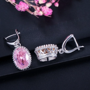 Close-up of pink oval gemstone earrings with silver crown-shaped setting details
