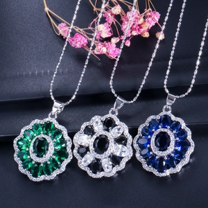 Macro view of three bohemian pendant necklaces with emerald, black, and blue gemstones