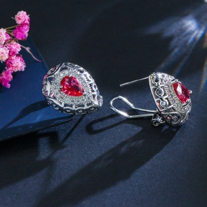 Macro di orecchini vintage color argento con zircone rosso a goccia e micro-pavé di strass