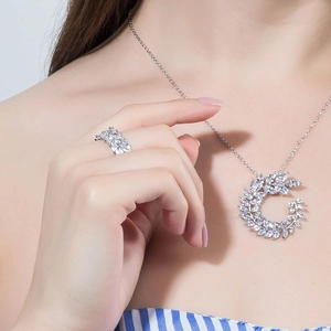 Elegante conjunto de joyas de circonio plateado con collar de pluma y anillo
