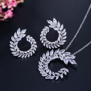Detalle de conjunto de joyería con collar y pendientes de circonita con forma de hoja