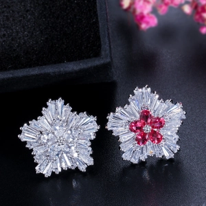 Detailed view of zircon flower stud earrings with red and white baguette-cut crystals