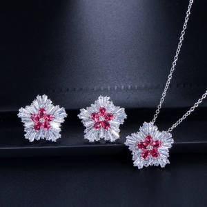 Macro detail of red zircon flower jewelry set with sparkling crystal stones on blue texture
