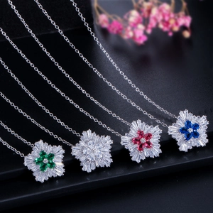 Close-up of four floral zircon necklaces in green, white, pink, and dark blue crystal