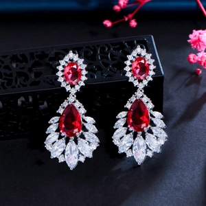 Macro detail of red pear-cut crystal teardrop earrings with silver-toned settings