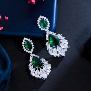 Detail of emerald green pear-cut drop earrings with shimmering marquise crystals