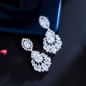 Close-up of teardrop sapphire crystal earrings with silver-tone metal and zircons