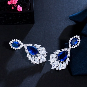Macro shot of silver drop earrings with blue sapphire and sparkling zircon clusters