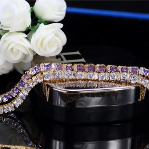 Bracelet tennis doré avec cristaux de zircone violets et blancs sur un écrin à bijoux