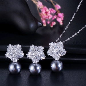 Dettaglio di pendente fiocco di neve in zircone e set orecchini con perle grigie