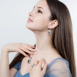Macro view of bridal jewelry set with pear-cut green zircon stones and white crystals