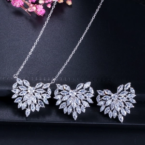 Macro shot of sparkling heart-shaped zircon necklace and earrings set on dark backdrop