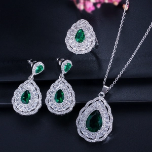 Macro view of pear-cut emerald zircon necklace set with double halo silver setting