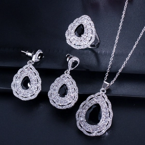 Macro shot of silver jewelry set with pear-cut black stones and white zircon accents