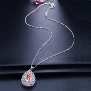 Detailed view of teardrop pendant with champagne gemstone and zircon halo on silver chain