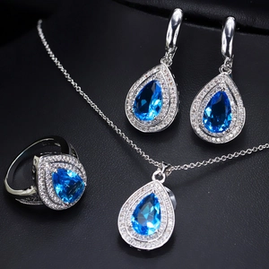 Macro detail of pear-cut blue zircon jewelry set with necklace, earrings, and ring