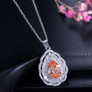 Macro view of pear-cut champagne zircon necklace with silver chain and halo setting